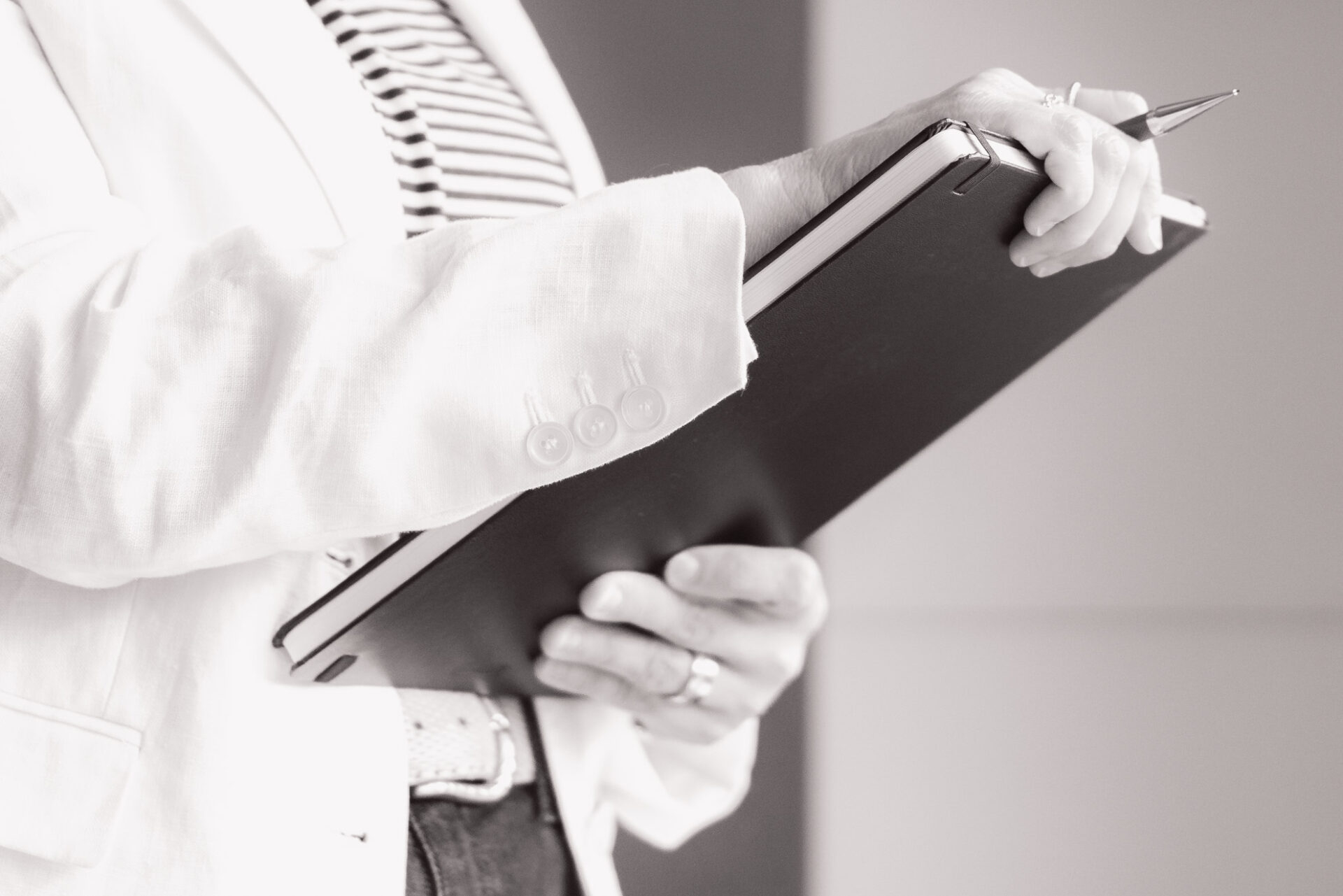 Janine Wettstein, Close-Up, hält Notizbuch und Bleistift in den Händen.